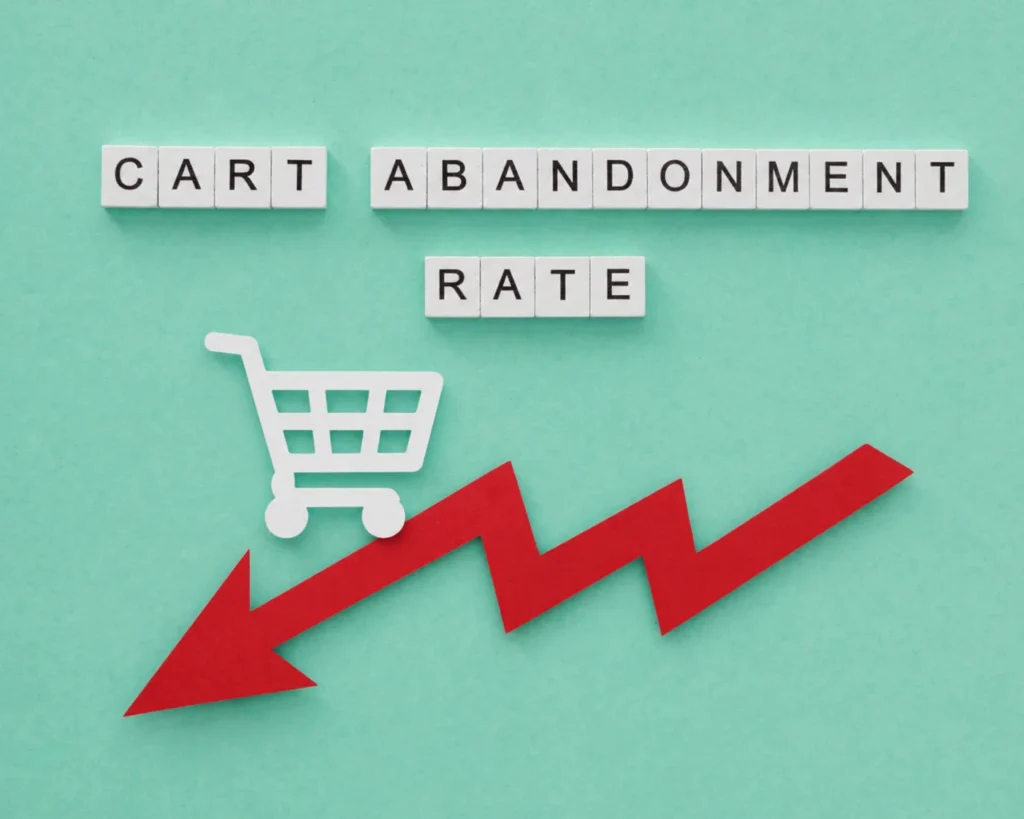 Letter tiles spelling Cart Abandonment Rate with a shopping cart icon and a downward red arrow showing how to reduce cart abandonment on Shopify